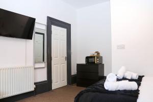 a bedroom with a bed with a television and towels at Roker all ensuite Guest House in Sunderland