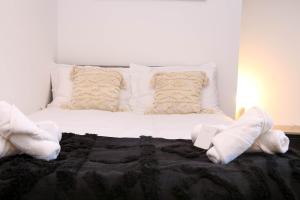 a bed with white pillows and a black blanket at Roker all ensuite Guest House in Sunderland