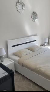 um quarto branco com uma cama e dois espelhos na parede em Modern & cozy 2-bedroom vacation home in Sarajevo em Sarajevo