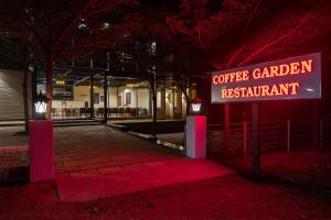 a sign that reads coffee garden restaurant at night at Global Village Luxury Resort in Chikmagalūr