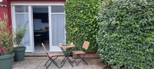 two chairs and a table in front of a building at Le Studio de Paulette in Cucq +5 photos