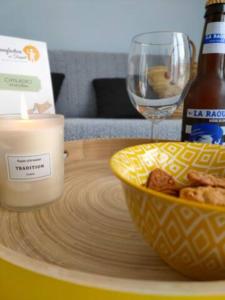 a candle and a bowl of food and a bottle of beer at Le Studio de Paulette in Cucq