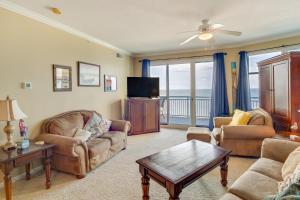 a living room with a couch and a tv at Beachfront Gulfport Vacation Rental with Balcony! in Gulfport