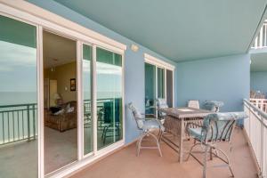 a porch with a table and chairs on a balcony at Beachfront Gulfport Vacation Rental with Balcony! in Gulfport