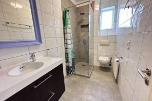 a bathroom with a sink and a shower and a toilet at Beautiful 2 bedroom apartment downtown Reykjavik in Reykjavík