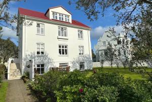 ein großes weißes Haus mit rotem Dach in der Unterkunft Beautiful 2 bedroom apartment downtown Reykjavik in Reykjavík