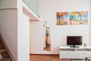 - un salon avec une télévision et un tableau mural dans l'établissement Gallery studio apartment, à Tel Aviv