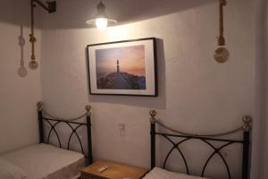 a room with two beds and a picture on the wall at CASA ALEGRIA in Algodonales