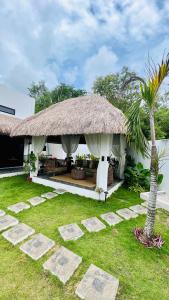 a house with a grass roof and a palm tree at Panglao Lofts in Panglao Island