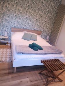 Un dormitorio con una cama blanca y una silla. en Studio neuf - accès SPA, SAUNA et Piscine Chauffée, en Saint-Vivien