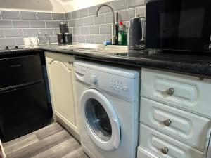 uma cozinha com uma máquina de lavar roupa e um lavatório em Stunning studio Apartment in Newport em Newport
