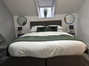 a bedroom with a large bed with two mirrors at Stunning studio Apartment in Newport in Newport
