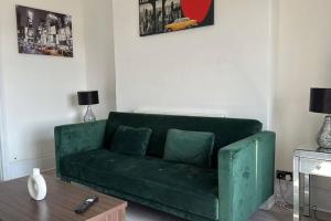 a green couch in a living room with a table at Captivating 1-Bed Apartment in Newport in Newport