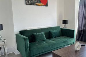 a green couch in a living room with a table at Captivating 1-Bed Apartment in Newport in Newport