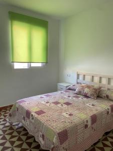 a bedroom with a bed with a quilt on it at Casa sebas in Puerto de Mazarrón +4 photos