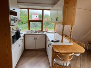 a small kitchen with a wooden table and a sink at Apartment dome Hof í Vatnsdal in Blönduós
