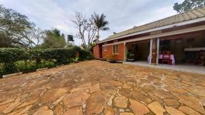 a stone driveway in front of a house at Philo Leisure Gardens in Kalangala