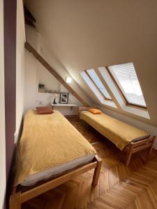 a bedroom with two beds and two skylights at Apartman 55 in Kikinda