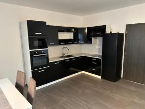 una cocina con electrodomésticos en blanco y negro y una mesa en Byt apartman 73m2 for 4people ALL NEW! 2023 en Praga