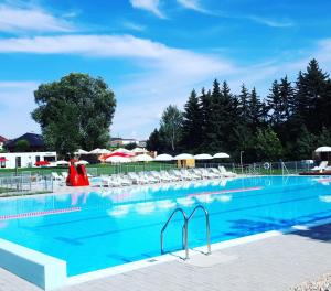 una gran piscina con sillas y sombrillas en Byt apartman 73m2 for 4people ALL NEW! 2023 en Praga