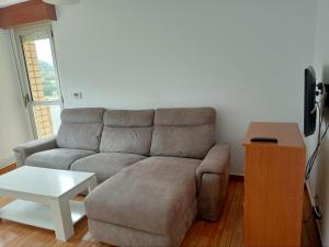 een woonkamer met een bank en een tafel bij La Arena Apartamentos Zierbena in La Arena