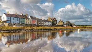 a group of houses sitting next to a body of water at Min y Don in Aberffraw