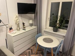 Cette petite chambre dispose d'un bureau, d'une table et d'une fenêtre. dans l'établissement Apartment Katowice Center-1, à Katowice
