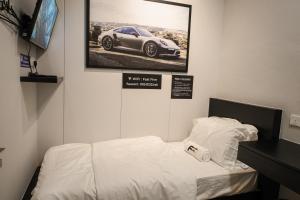 Tanjong Tokong的住宿－FAST FIVE At Gurney，一间房间,配有一张床,墙上挂着一幅汽车照片
