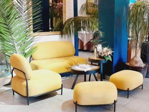 four yellow chairs and a table in a room at La Varangue in Antananarivo