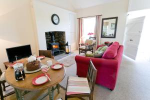 a living room with a red couch and a table at Penlon in Rhosneigr