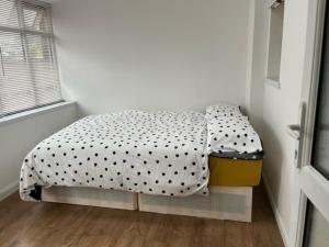 een slaapkamer met een bed met een polka dot-deken bij 10 Valley Road, in Kent