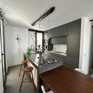 a kitchen with a wooden table and a kitchen with black cabinets at Caretta Caretta's House in Los Llanos de Aridane