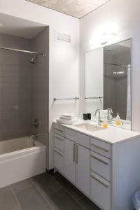 a bathroom with a sink and a tub and a mirror at 2BR Executive Suite With Fast Wi-Fi in Chicago