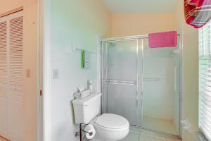 a bathroom with a toilet and a glass shower at Charming St Lucie River Retreat with Pool and Dock! in River Park +19 photos