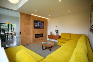 a living room with a yellow couch and a table at Dillon School House - Luxury in the countryside in Roscommon