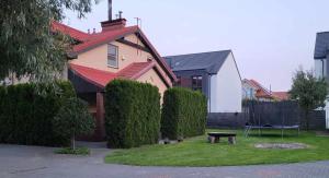 a house with a red roof and a bench in the yard at Apartament Mewa Gdańsk in Gdańsk