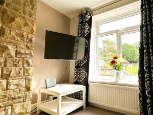TV a/nebo společenská místnost v ubytování Cosy Country Escape | Fireplace & Views | Leeds & York