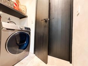 een wasmachine en droger in een badkamer met een deur bij Vida Jungle Boho Apart 14 with special fee to access Hotel Bardo in Tulum