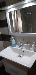 - un lavabo avec miroir et une bouteille de savon dans l'établissement Apartament 2 camere, à Bacău