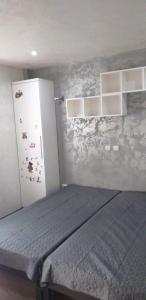 - une chambre avec un lit et un réfrigérateur dans l'établissement Apartament 2 camere, à Bacău