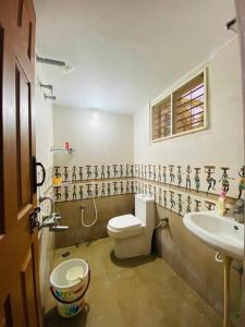 a bathroom with a toilet and a sink at Pal's Cottage in Mysore