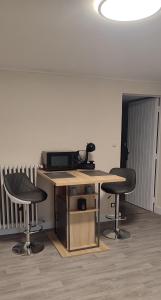 Allonnes的住宿－Les Cytises，办公室配有带2把椅子的书桌和电话