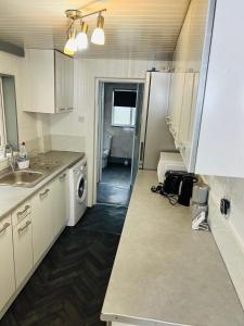a kitchen with a sink and a washer and dryer at Great Accommodation in Medway in Gillingham