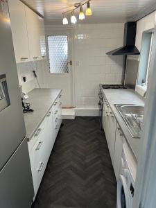 a kitchen with white cabinets and a sink in it at Great Accommodation in Medway in Gillingham