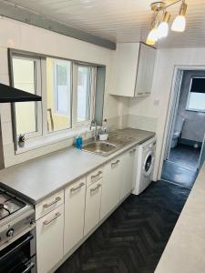 a kitchen with a sink and a washing machine at Great Accommodation in Medway in Gillingham