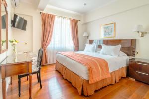 a hotel room with a bed and a desk at Orly Suites in Santiago