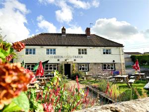 una vieja posada mística de arpa con flores delante en Cute Country Cottage near Leeds & York, en Leeds