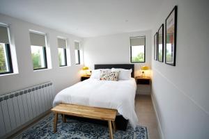 1 dormitorio blanco con 1 cama y 2 ventanas en Dillon School House - Luxury in the countryside, en Roscommon