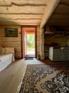 Saula的住宿－Metsakuurorti puhkekeskus, Mummila house，一间设有床的房间和一扇带地毯的门