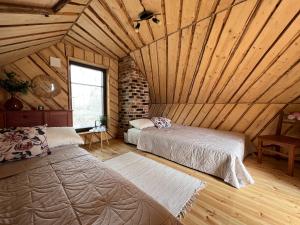 Saula的住宿－Metsakuurorti puhkekeskus, Mummila house，一间带两张床的卧室,位于木天花板的房间